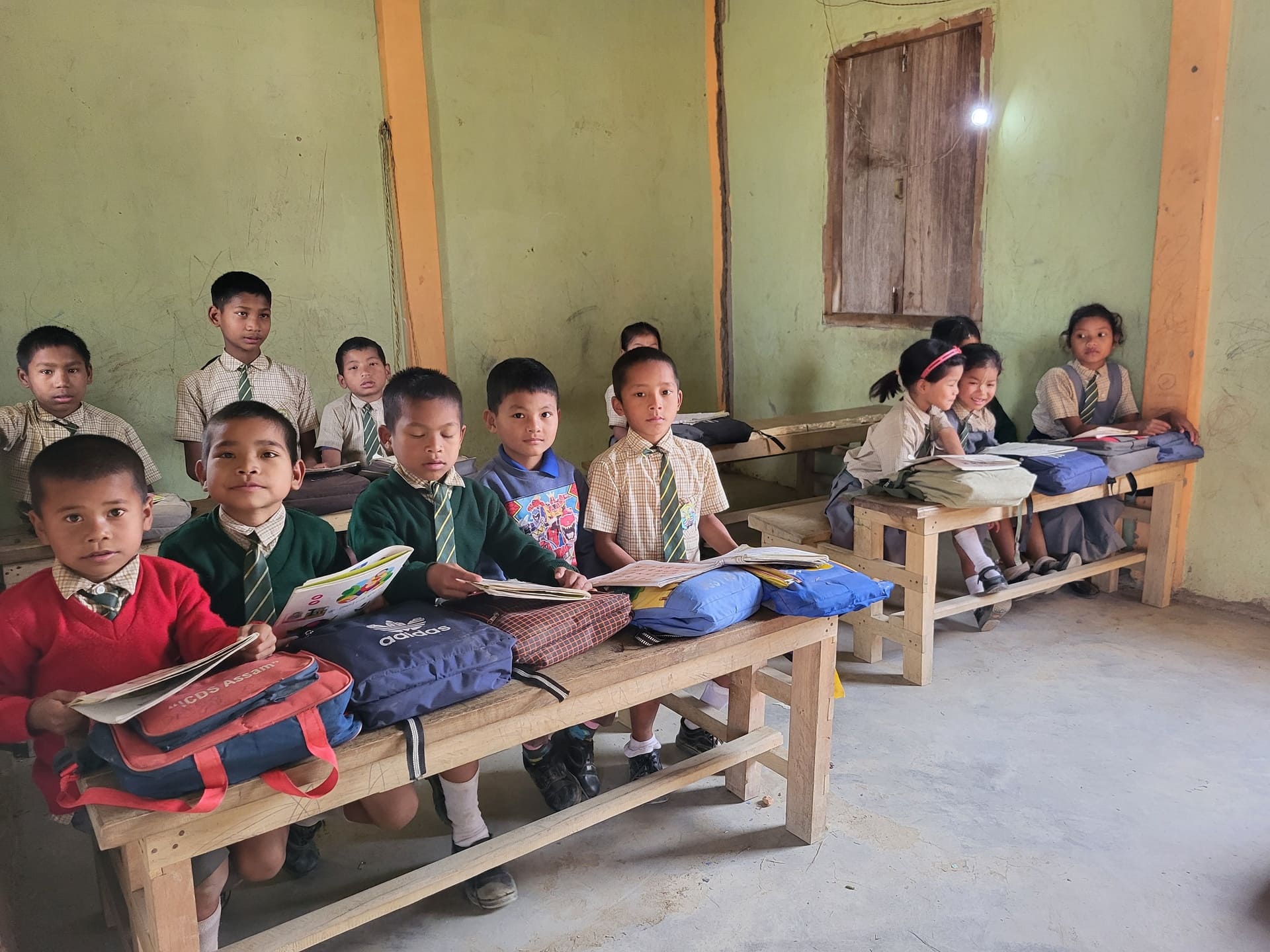 Children focused on their evening studies inside a well-lit classroom environment